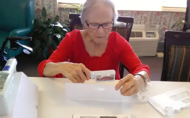 A woman is using assitive tools to help get her work done easier.