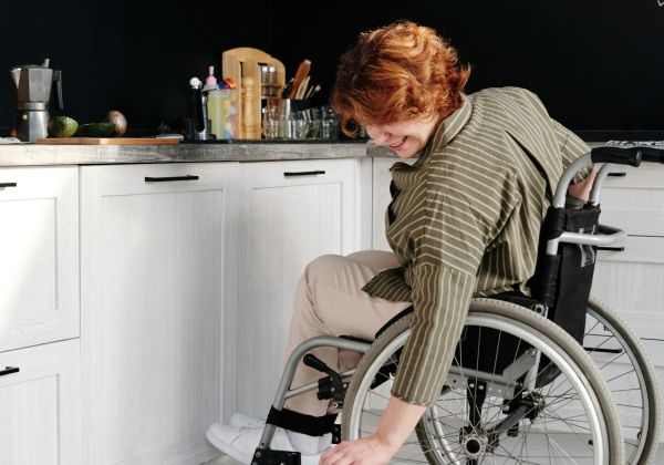 Woman in wheelchair petting her cat.
